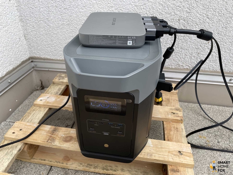 Der EcoFlow DELTA 2 Max Solargenerator und Notstromaggregat steht auf einer Palette und der EcoFlow Powerstream Wechselrichter liegt drauf.